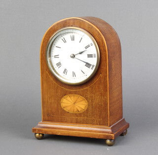 An Edwardian timepiece with enamelled dial and Roman numerals, contained in an arched inlaid mahogany case, raised on bun feet, complete with key 