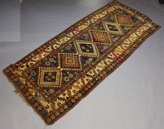 A blue and tan ground Caucasian style rug with 6 diamonds to the centre within a multi row border 308cm x 135cm 
