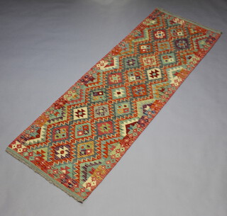 An orange, green and turquoise ground Chobi Kilim runner with all over geometric designs 240cm x 81cm 