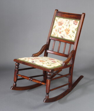 A late Victorian mahogany rocking chair with upholstered seat and back