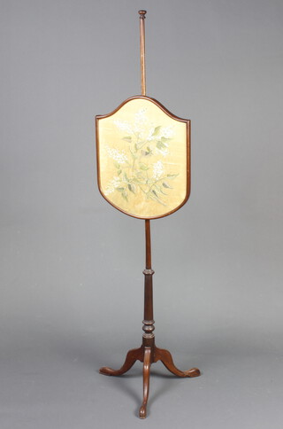 An Edwardian shield shaped pole screen raised on a turned mahogany column and tripod base with floral banner 152cm h x 49cm 