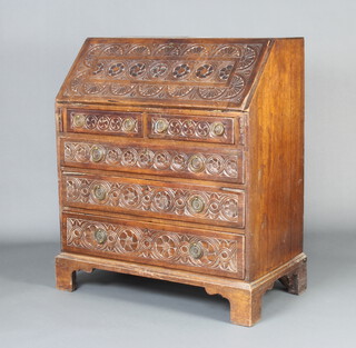 A Georgian carved mahogany bureau, the fall front revealing a fitted interior above 2 short and 3 long drawers, raised on bracket feet 108cm h x 92cm w x 51cm d 
