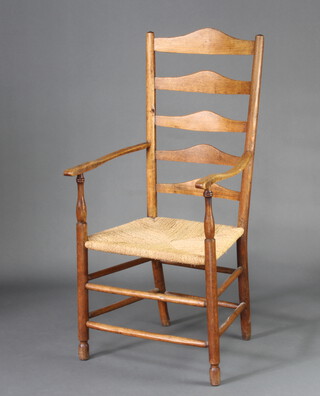 An Edwardian elm ladder back carver chair with woven rush seat, raised on turned supports 