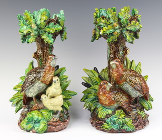 Hugo Lonitz & Co 1868-1904, a pair of Majolica stands with grouse and chicks before bulrushes against an oak tree, the column encrusted with acorns and oak leaves.  One base impressed with double fish mark and 1203, the other J.R.1204, 31cm h x 16cm diam.  