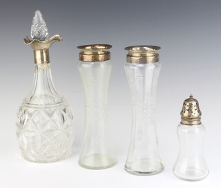 An Edwardian glass sugar caster with silver lid Birmingham 1901, a pair of cut glass specimen vases with silver collars Birmingham 1925 23cm, a cut glass decanter and stopper with silver collar (neck f) 
