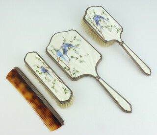A silver and enamelled 3 piece dressing table set comprising hair brush, hand mirror and clothes brush, decorated butterflies, London 1953, together with an associated comb with silver mount, makers Padgett and Barnham Ltd   