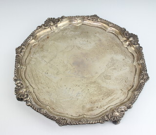 A silver salver with shell and scroll rim, raised on scroll feet with engraved signatures, London 1904, 33cm, 1038 grams