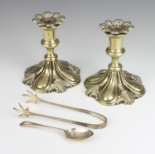 A pair of plated repousse candlesticks, pair of ice tongs and a teaspoon