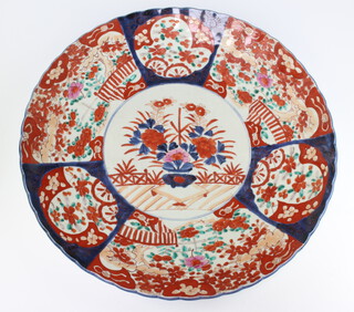 A 19th Century Japanese Imari charger decorated a basket of flowers and with panel decoration, lobed rim, 47cm 