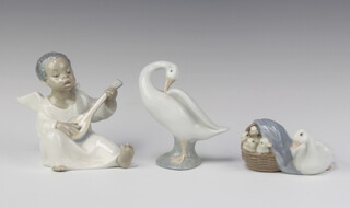A Lladro figure of a seated goose and goslings in a basket, base marked 4895 9cm, ditto standing goose 10cm, ditto seated angel playing a mandolin impressed A-13M 13cm 