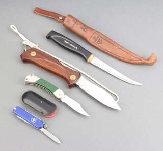 A Victorinox pocket knife, a Swedish EKA folding knife with wooden grip, a Puma Ranbule 455 folding pocket knife with green grip and a Mark filleting knife with 10cm blade and leather scabbard