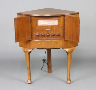 A G Marconi radio, model no. C10 A, serial number A/11 1031, contained in a walnut corner cabinet enclosed by panelled doors, raised on cabriole supports 76cm h x 46cm w x 65cm d