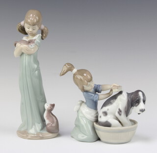 A Lladro figure of a kneeling girl scrubbing a hound dog, base marked 5455 11cm, ditto girl with kitten 5743 21cm  