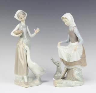 A Lladro figure of a standing lady with seated rabbit, base impressed 4826 23cm h together with 1 other lady with goose and basket of seed 26cm h 