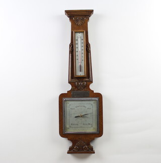 A Shortland 1950's aneroid barometer and thermometer with silvered dial contained in a carved walnut and crossbanded wheel case, the dial marked SB  