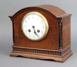 An Edwardian striking mantel clock with enamelled dial and Arabic numerals contained in an arched mahogany case 