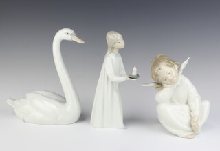 A Lladro figure of a standing girl with chamber stick, base impressed E2N 21cm (f and r), ditto seated angel E28D (wing f and r) and a swan 5220 20cm 

