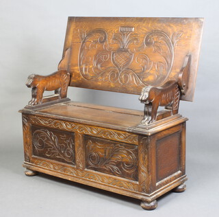 A carved oak monks bench with lion arms, raised on bun feet, 67cm h x 105cm w x 48cm d 