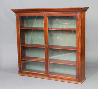 An Edwardian walnut display cabinet with moulded cornice, fitted adjustable shelves enclosed by glazed panelled doors 123cm h x 134cm w x 32cm d 