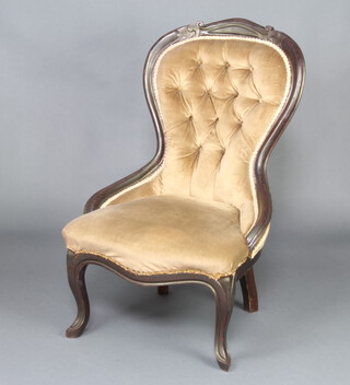 A Victorian ebonised mahogany show frame nursing chair upholstered in mushroom buttoned material, raised on cabriole supports (slight movement to the frame)  