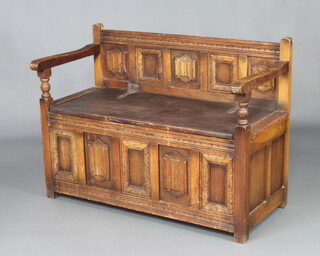 A carved oak hall settle with linenfold decoration 74cm h x 99cm w x 48cm d, the reverse with label "A genuine product of the Wood Brothers" 
