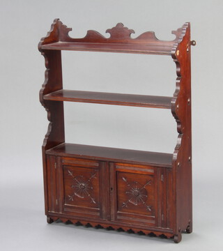 An Edwardian mahogany hanging 3 tier wall shelf, the base enclosed by panelled doors 83cm h x 60cm w x 16cm d 