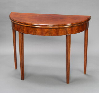A Georgian mahogany demi-lune card table raised on square tapered supports 73cm h x 96cm w x 45cm d  