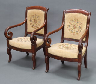 A pair of Empire style mahogany show frame open arm chairs, seats and backs upholstered in Berlin woolwork panels, raised on scroll supports 