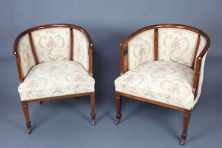 A pair of Edwardian inlaid mahogany tub back chairs upholstered in tapestry material, raised on square tapered supports, spade feet 
