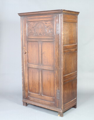 A 17th Century style carved oak hall wardrobe enclosed by a panelled door 173cm h x 100cm x 53cm 