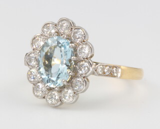 An 18ct yellow gold oval aquamarine and diamond cluster ring, centre stone 1.8ct, surrounded by brilliant cut diamonds 0.9ct, size O 