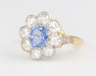A yellow gold sapphire and diamond cluster ring, the centre stone approx. 1.3ct surrounded by brilliant cut diamonds 1.15ct