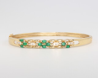 A 14ct yellow gold emerald and diamond bangle, 14 grams
