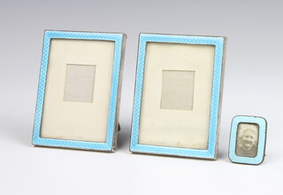 A pair of silver and blue enamel easel photograph frames, London 1923 9cm x 4cm together with a blue enamelled ditto 3cm x 2.5cm 