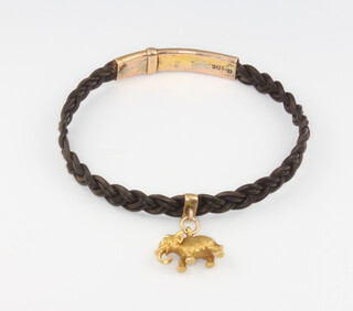 A gold mounted bracelet with a yellow gold elephant charm 