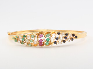 An 18ct yellow gold diamond, ruby, sapphire and emerald bangle, 11.4 grams 