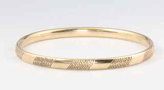 A 9ct yellow gold engraved bangle 5.7 grams