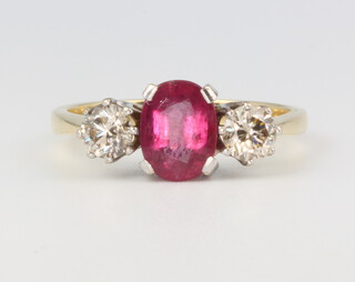 An 18ct yellow gold ruby and diamond ring, the centre oval stone approx. 1.5ct, flanked by 2 brilliant cut diamonds approx. 0.8ct, size R 1/2