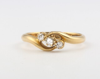 An 18ct yellow gold cross-over 3 stone diamond ring size K 1/2, 2.5 grams