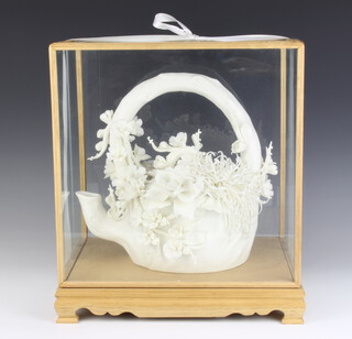A Chinese porcelain model of a floral encrusted teapot, contained in an light oak display cabinet 36cm x 32cm x 23cm 