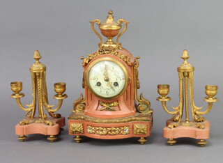 A Vincent and Gie 19th Century French 3 piece clock garniture comprising striking on bell mantel clock with enamelled dial and Roman numerals, the back plate marked Vincent and Gie and numbered 3980, contained in a pink marble and gilt ormolu case surmounted by a lidded urn together with a pair of twin light candelabrum 