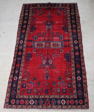 A red and blue ground Afghan rug the central medallion within a multi row border 292cm x 155cm 