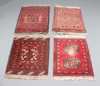 Four Afghan red and black ground slip rugs 68cm x 52cm 