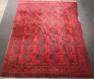 A red and black ground Afghan carpet with 28 octagons to the centre within a multi row border 371cm x 290cm 