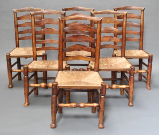 A set of 6 19th Century elm ladderback dining chairs with woven rush seats raised on turned supports