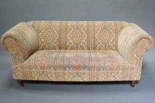 A Victorian style Chesterfield sofa upholstered in tapestry material raised on turned supports 70cm h x 182cm w x 92cm d 