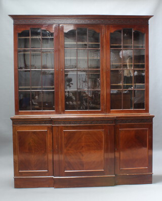 An Edwardian Chippendale style mahogany bookcase, the upper section with moulded and dentil cornice and blind fretwork frieze, fitted adjustable shelves enclosed by 3 astragal glazed panelled doors, the breakfront base with 3 panelled doors, raised on a platform base 222cm h x 183cm w x 48cm d 