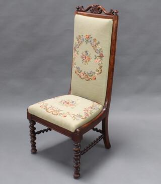 A Victorian rosewood framed nursing chair, the back and seat upholstered in Berlin woolwork material, raised on spiral turned supports and stretcher 