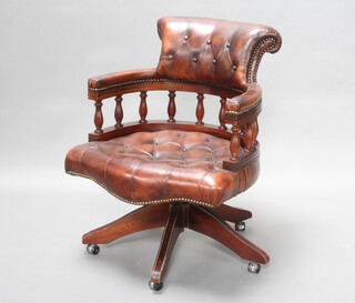A tub back revolving office chair upholstered in brown buttoned leather 
