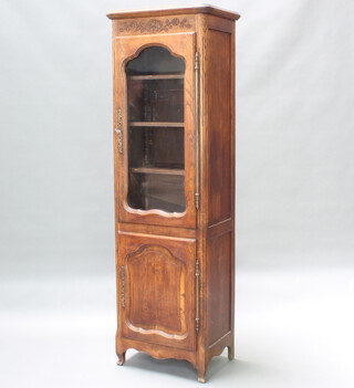 A French carved oak bookcase, the upper section with moulded cornice fitted adjustable shelves, the base enclosed by a panelled door, raised on cabriole supports 175cm h x 54cm w x 37cm d 